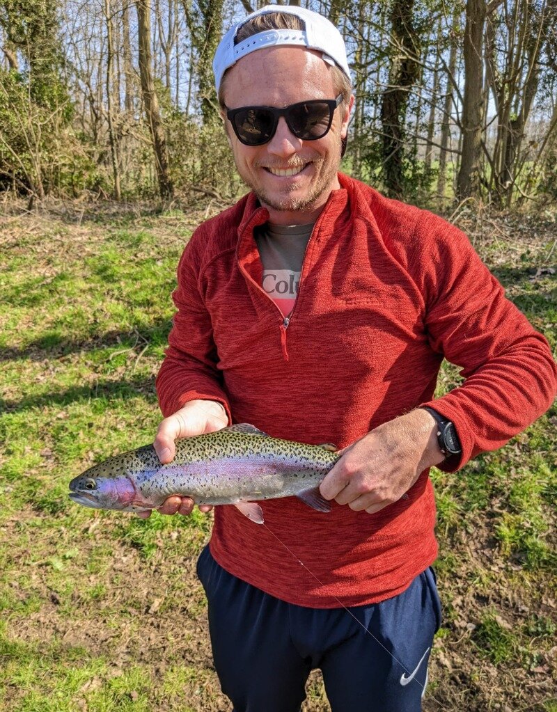 Me holding a trout caught on a fly in London