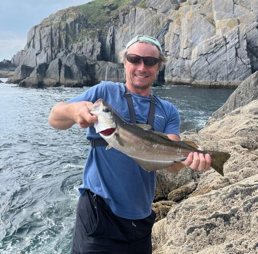 Me holding a big pollock in front of a cliff in the Beara Peninsula