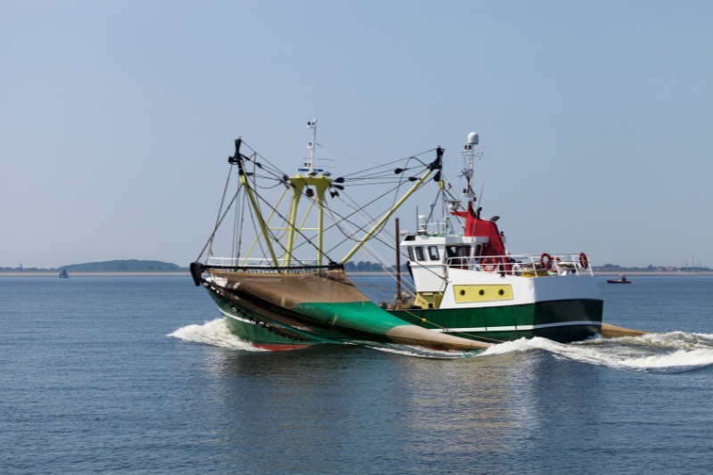 A medium sized fishing boat with huge gill nets