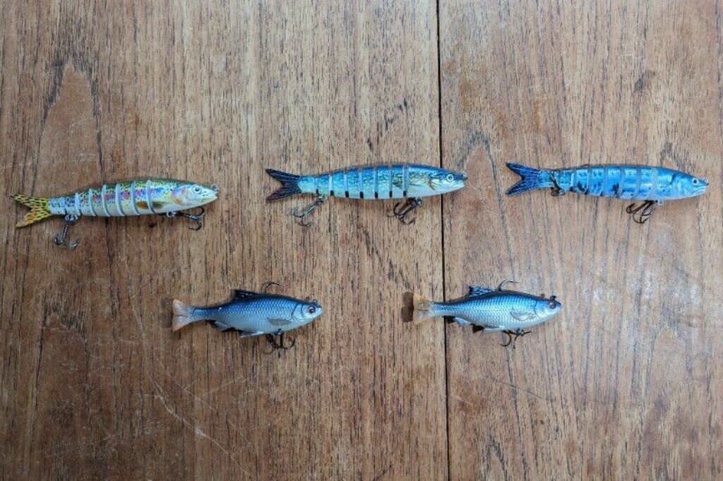 Trout and coarse fish imitation pike lures on a wooden table