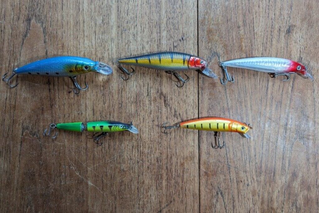 A variety of hard surface lures in a range of colours on a wooden table