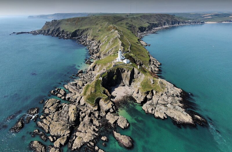 An aerial view from the sea of Start Point Lighthouse