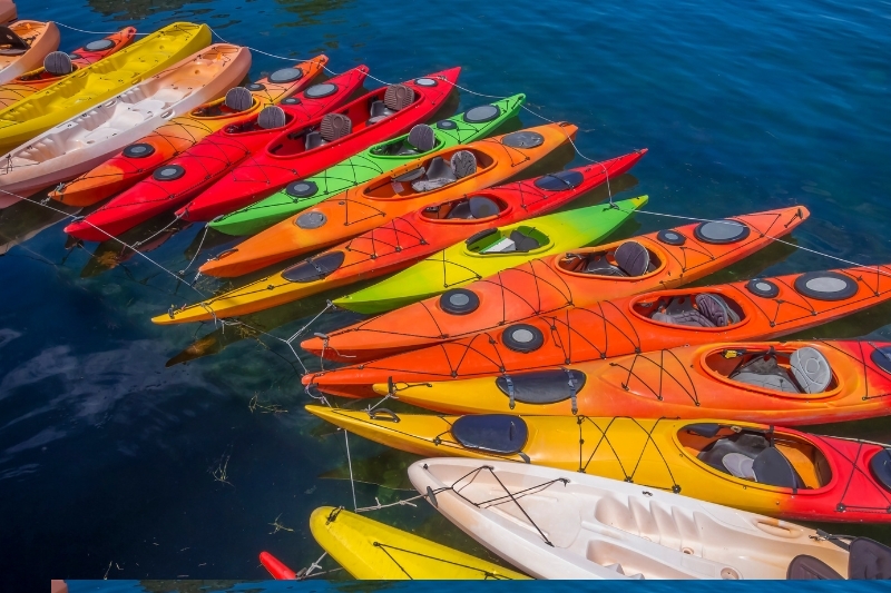 Multiple kayaks sitting together in the water