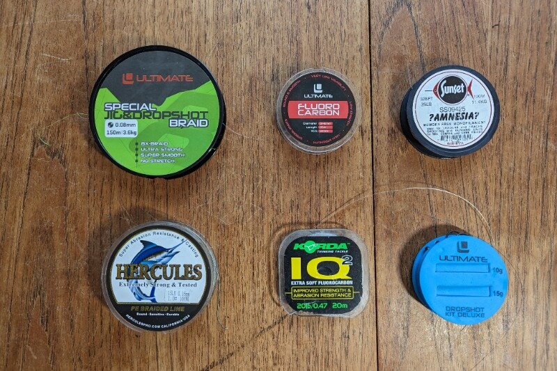 Six braided lines and fluorocarbon leaders laid out on a wooden table