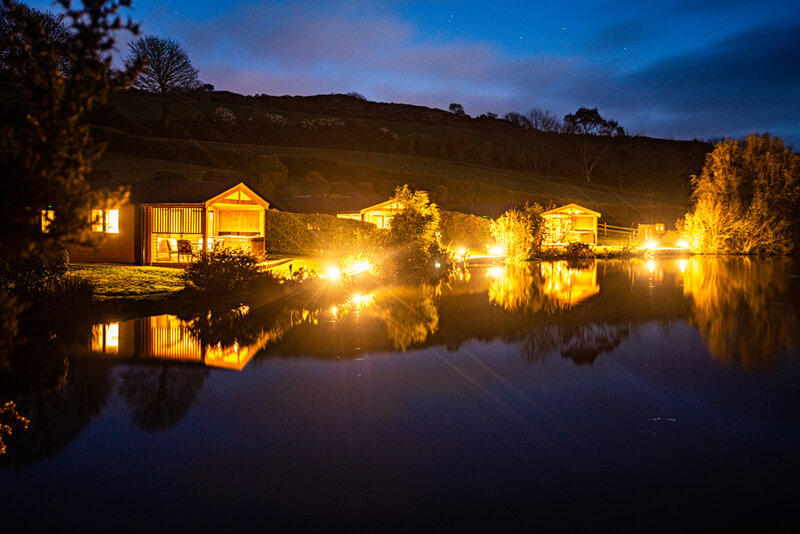 Nanpusker Lakeside Lodges at night with lights over the lake