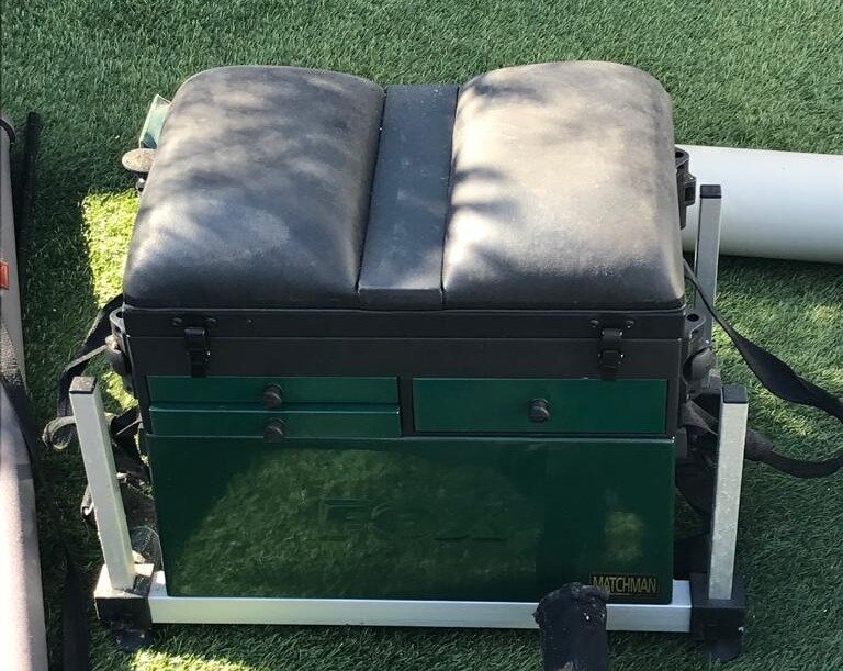 A fishing seat and tackle box hybrid on astro turf